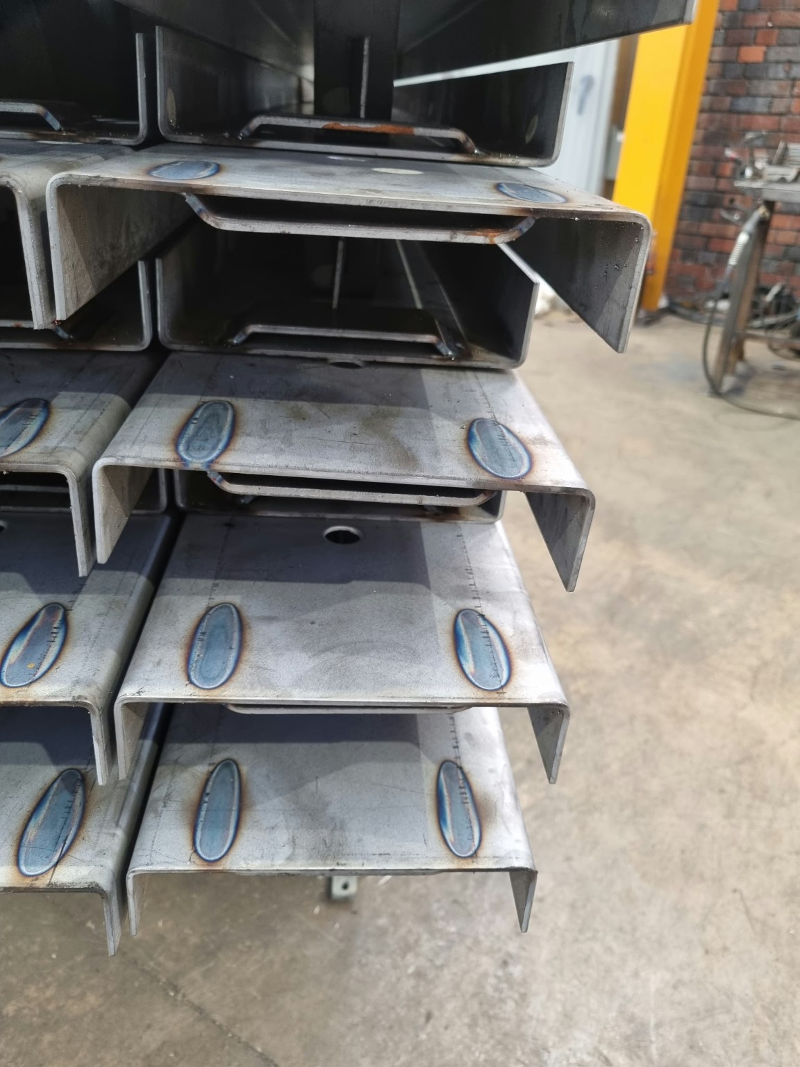 Stacked rigid road forms showing formed steel end sections and weld details